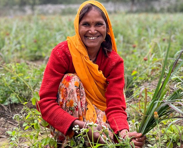Ambu Bhabhi, smiling, cutting lemongrass
